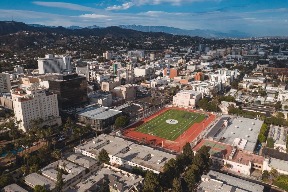Ultimate LA Private Doors-Off Aerial Photography Helicopter Adventure Review Review 2026 - Stunning aerial view of Los Angeles cityscape featuring a prominent football field in the foreground.