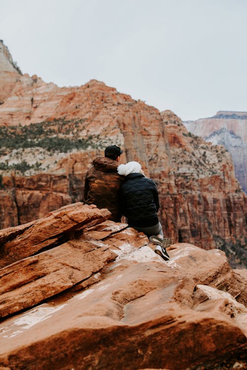 Free Couple Sitting on Rock Cliff Stock Photo