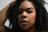 一位拥有自然卷发的美丽女子的特写肖像，展现了自信和优雅