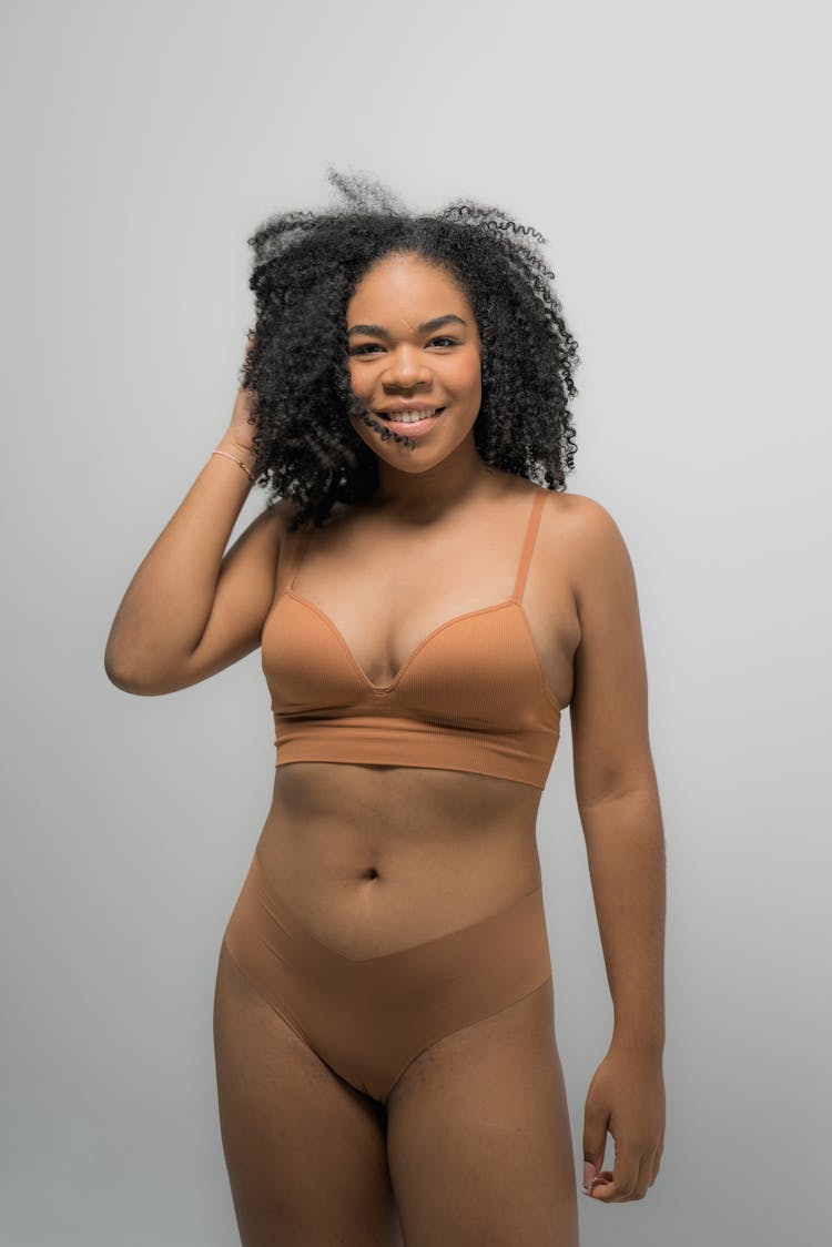 Woman In Brown Undergarments Posing Beautifully At The Camera