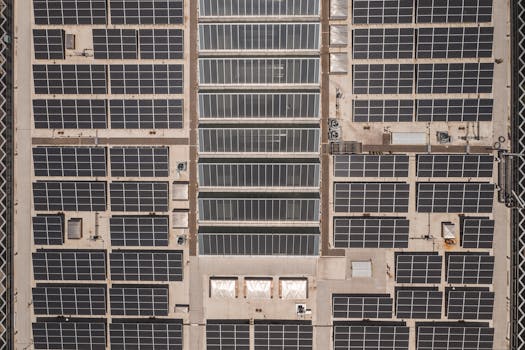 Photo by RDNE Stock project A high-angle drone shot capturing a grid of solar panels on a large industrial rooftop, showcasing renewable energy.