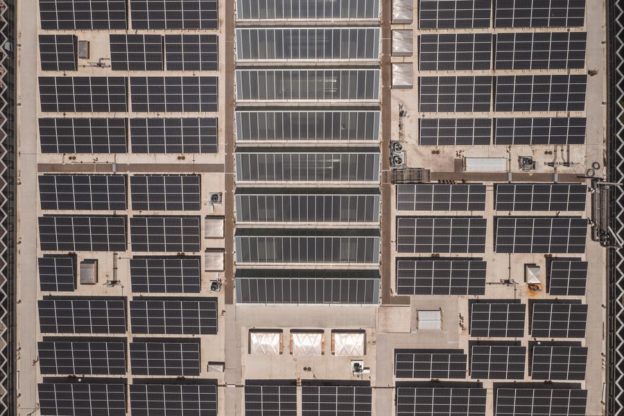 High angle drone shot of solar panels covering a rooftop