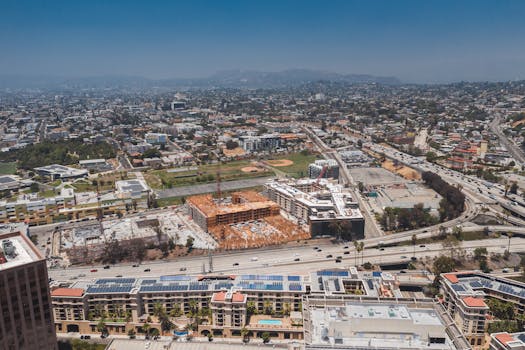 Aerial view showcasing the urban sprawl of Los Angeles with construction sites and highways visible.