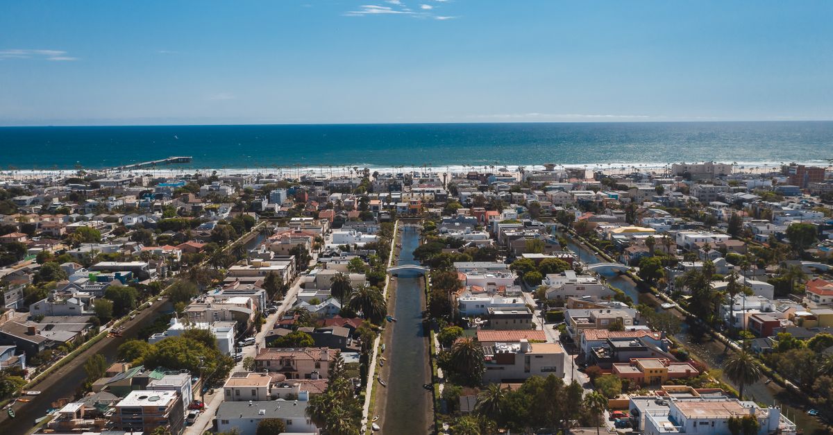 Stunning aerial view of a coastal cityscape with canals leading to the ocean horizon.