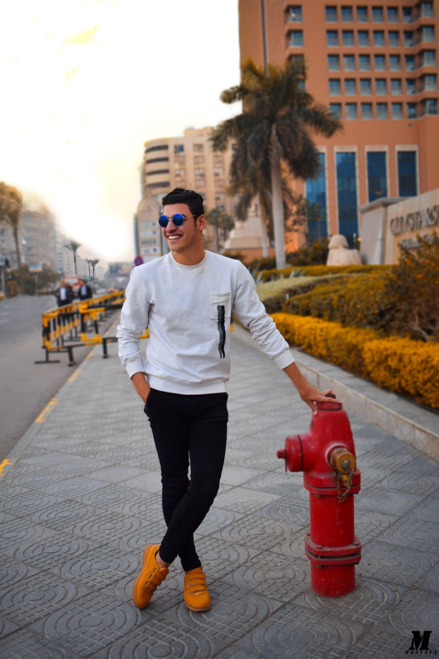 Man in a white sweatshirt walking on a city street