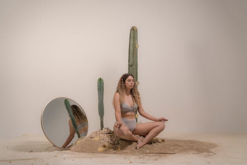 Woman in White Bikini Sitting on Brown Rock