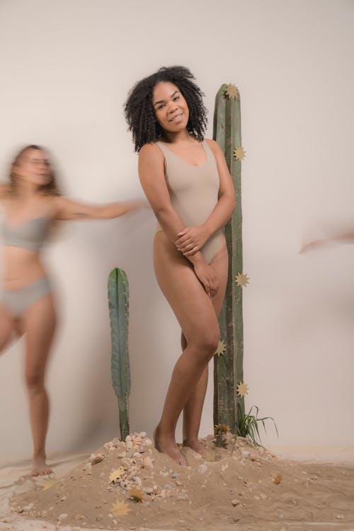 Woman in Teal Bikini Standing Beside Green Wooden Pole