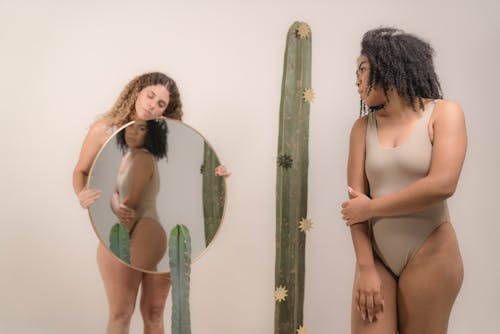 Woman in White Bikini Standing Beside Green and White Wall