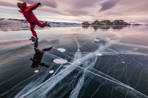 Free Man Ice Skating on a Frozen Lake  Stock Photo