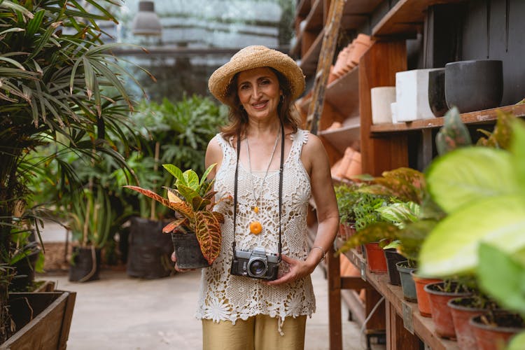 Elderly Woman Holding A Potted Plant