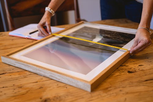 Person Measuring a Wooden Frame