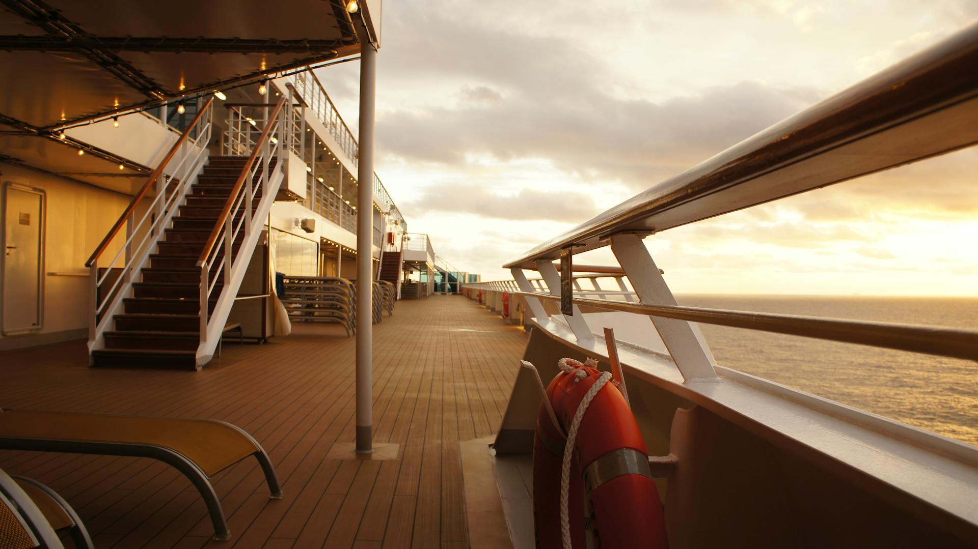 A serene view of a cruise ship deck at sunset, highlighting the peaceful ocean journey.