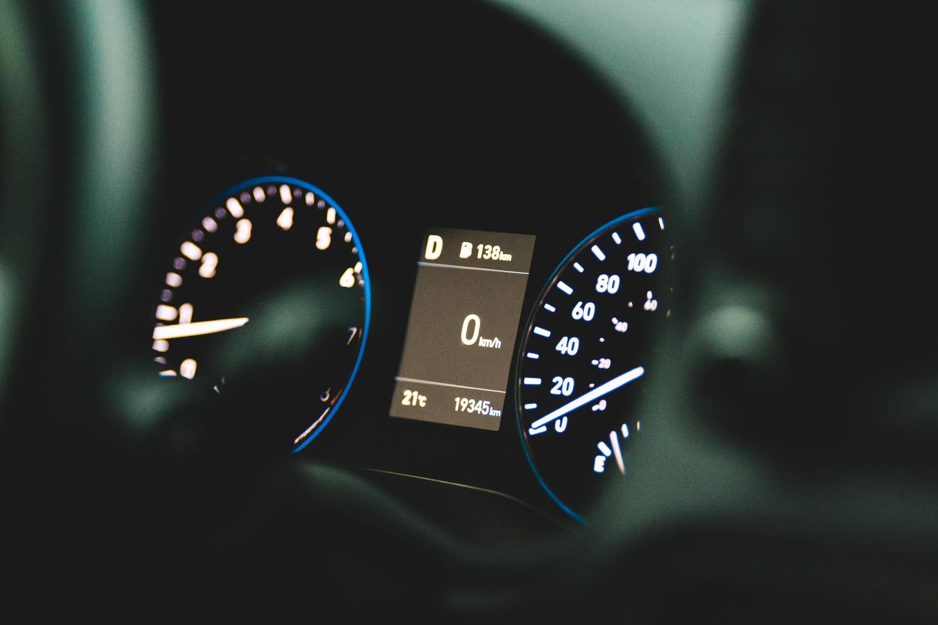 A detailed view of a car's dashboard display showing zero speed and odometer reading of 19345 km.