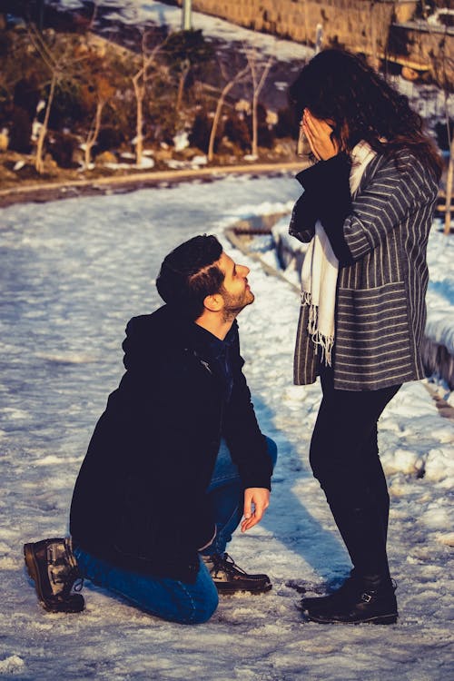 Free Man Kneeling in Front of Woman Stock Photo