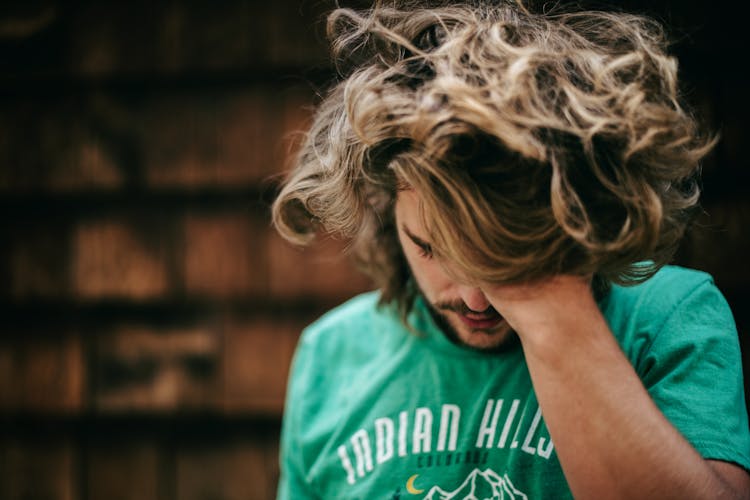 Man In T-Shirt Touching Long Hair