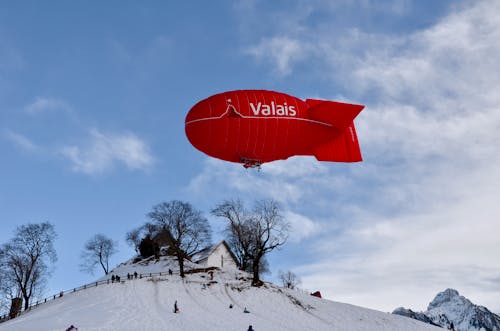 Dirigeable Valais Rouge Au Dessus De La Maison En Bois Blanc