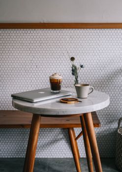Marble cafe table with laptop, coffee, and decor in Jakarta. Perfect for remote work.