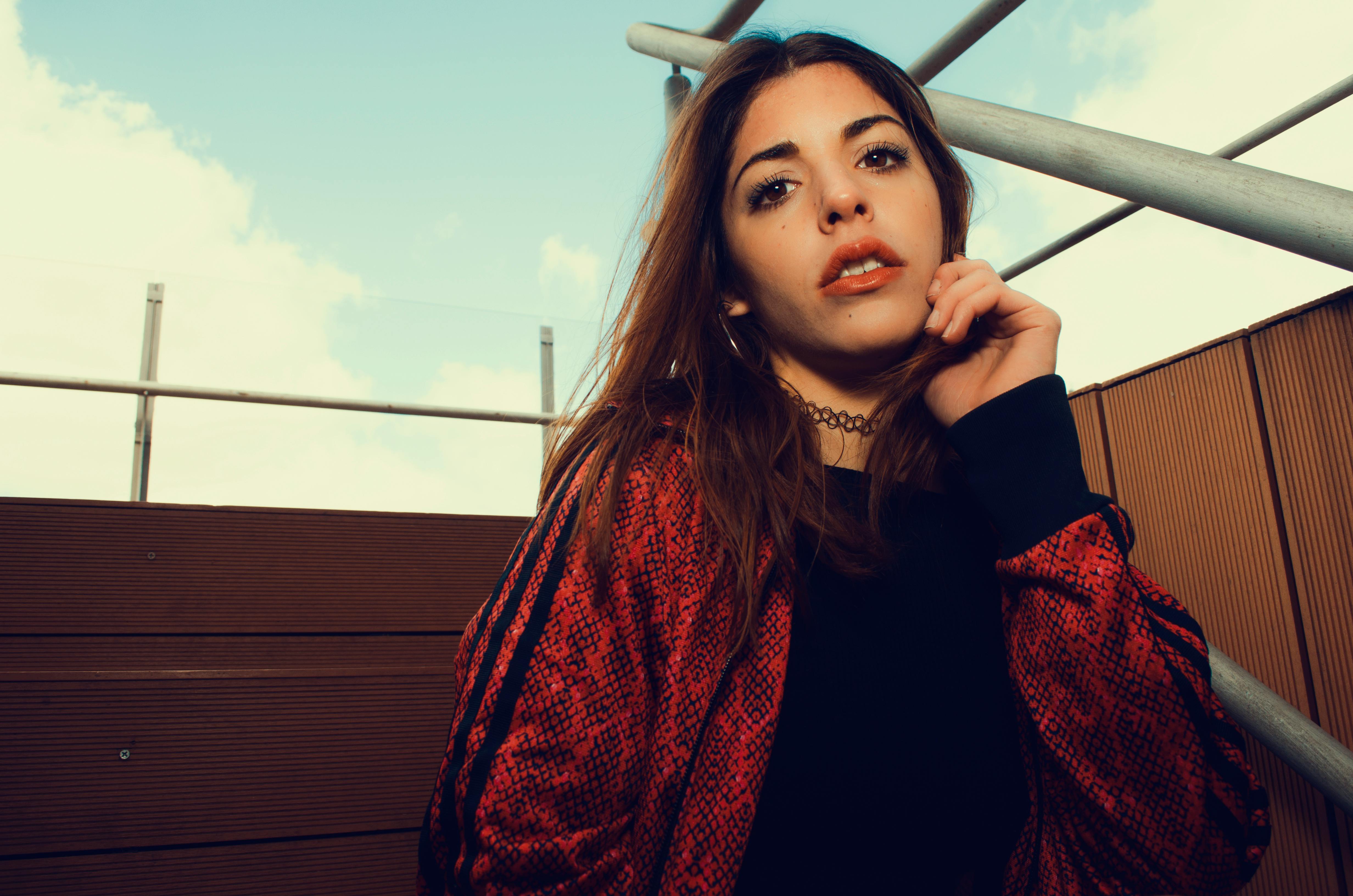 一位穿着红色夹克在户外的时尚年轻女子的肖像