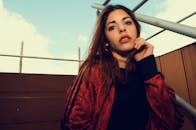 一位穿着红色夹克在户外的时尚年轻女子的肖像