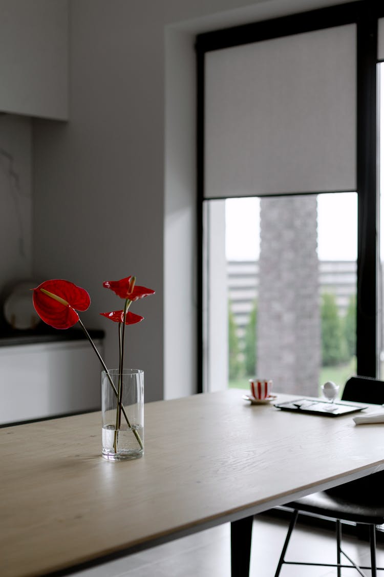 A Flower Vase With Anthurium Over The Table