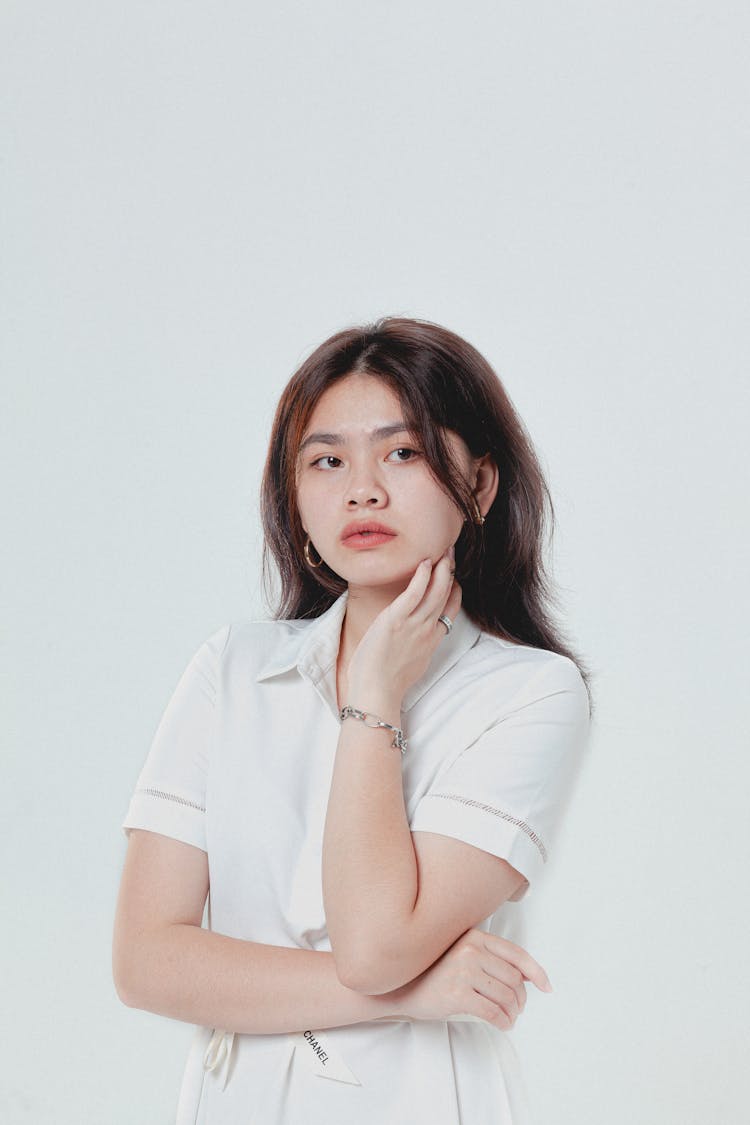 Woman In White Button Up Shirt Touching Her Chin 