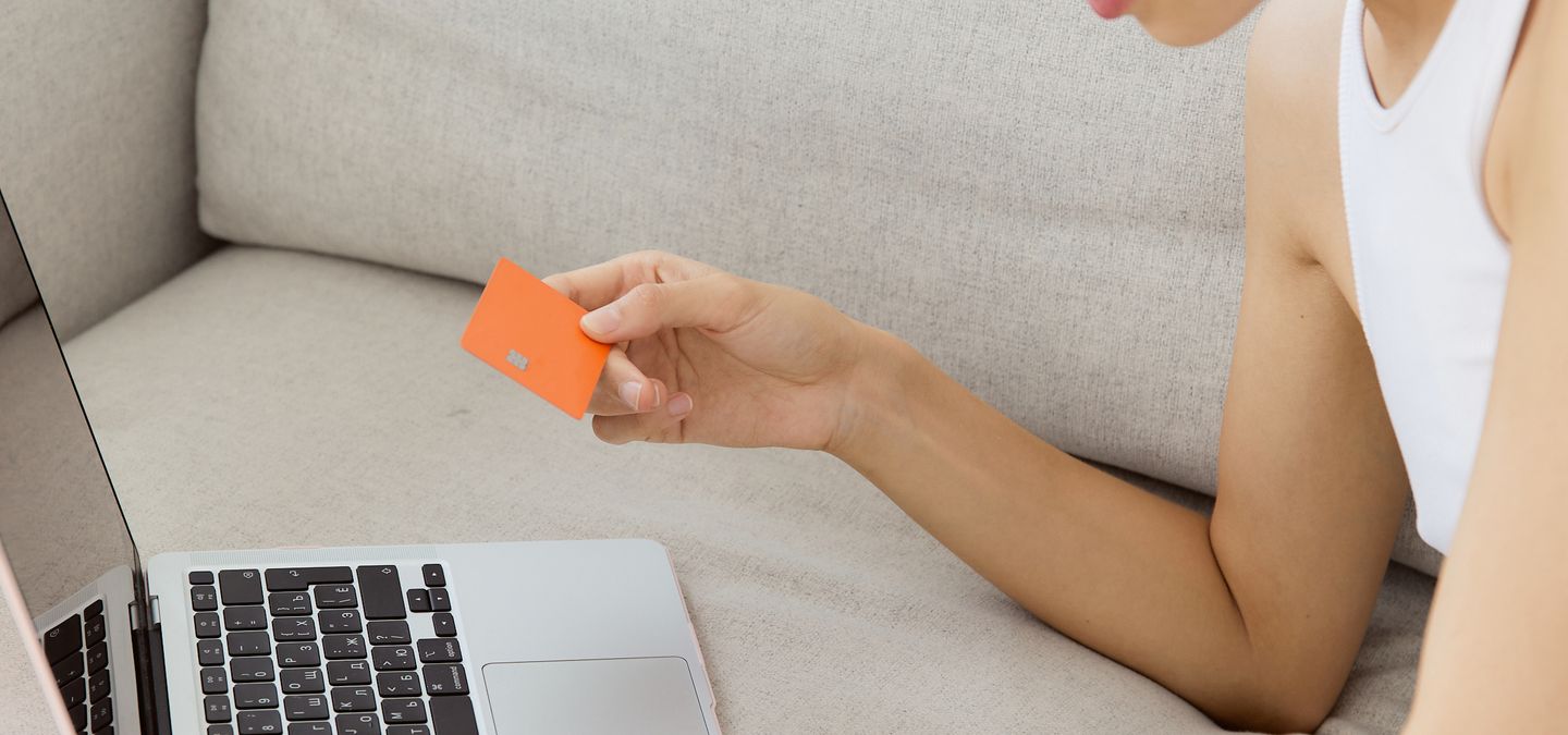 Person shopping online with a card and laptop