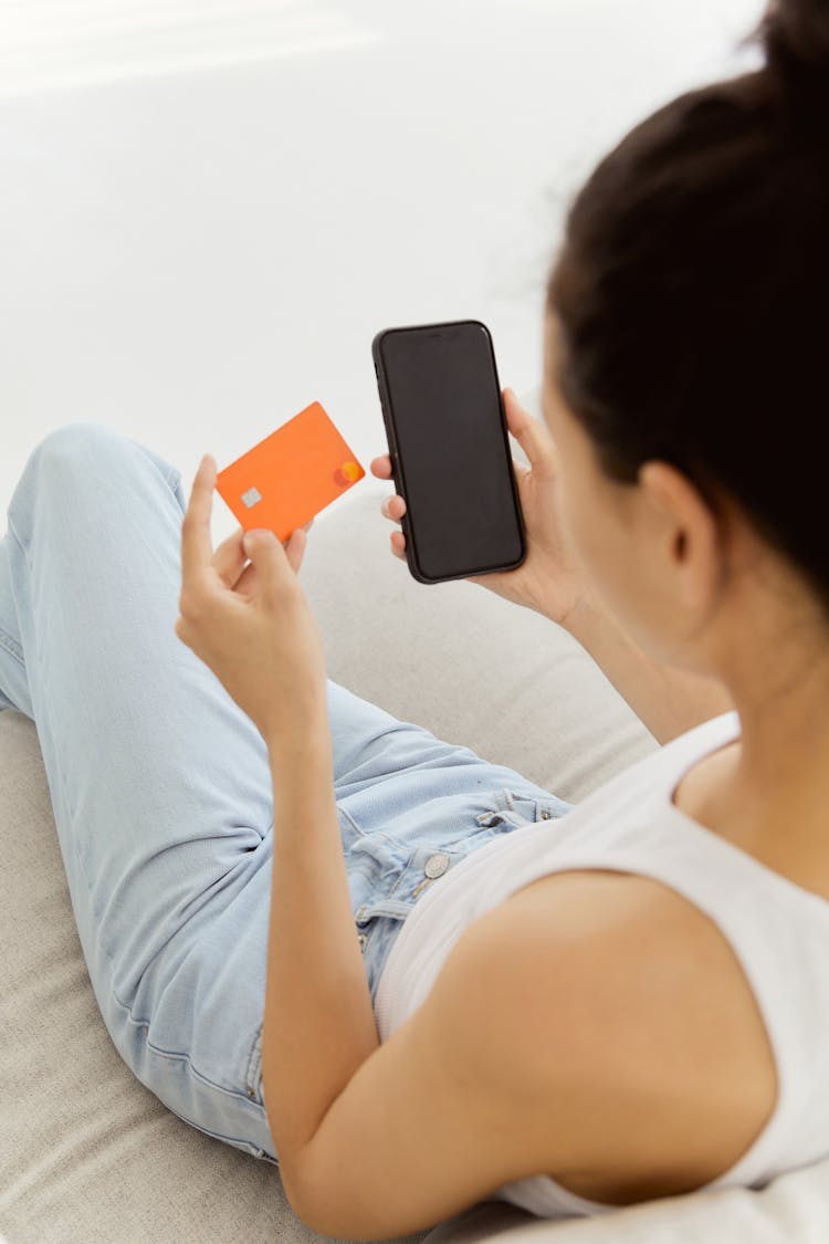 Woman In White Tank Top Holding Smartphone And Credit Card