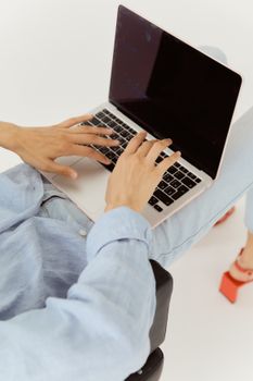 Overhead shot of a woman online shopping on a laptop with a white background.