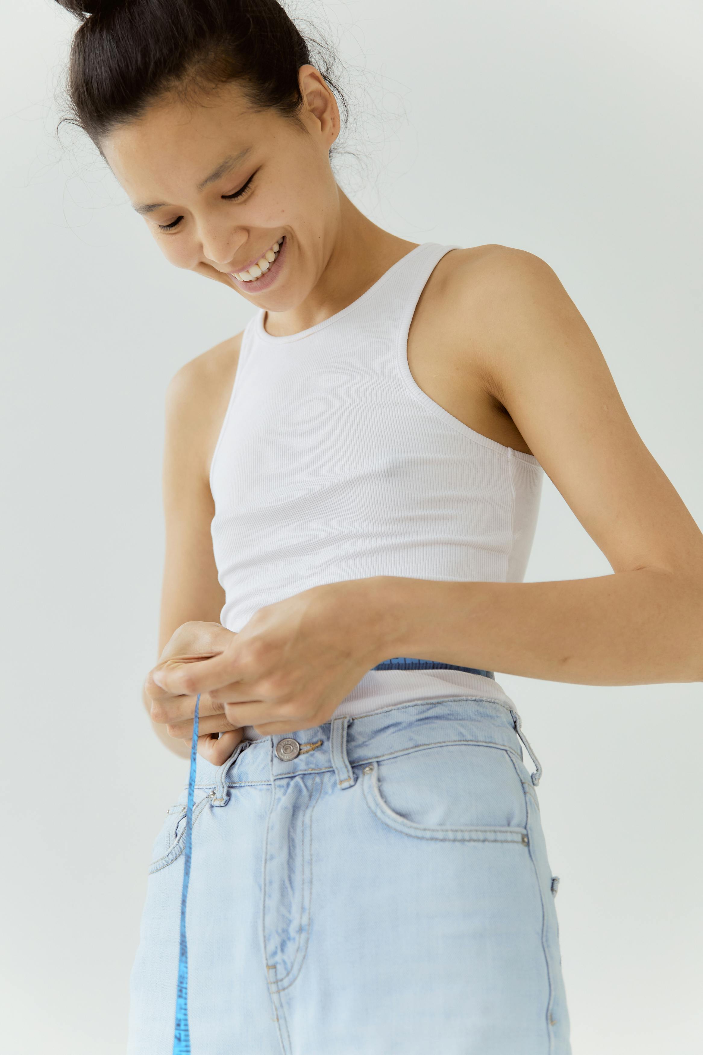 woman in white tank top and blue denim jeans