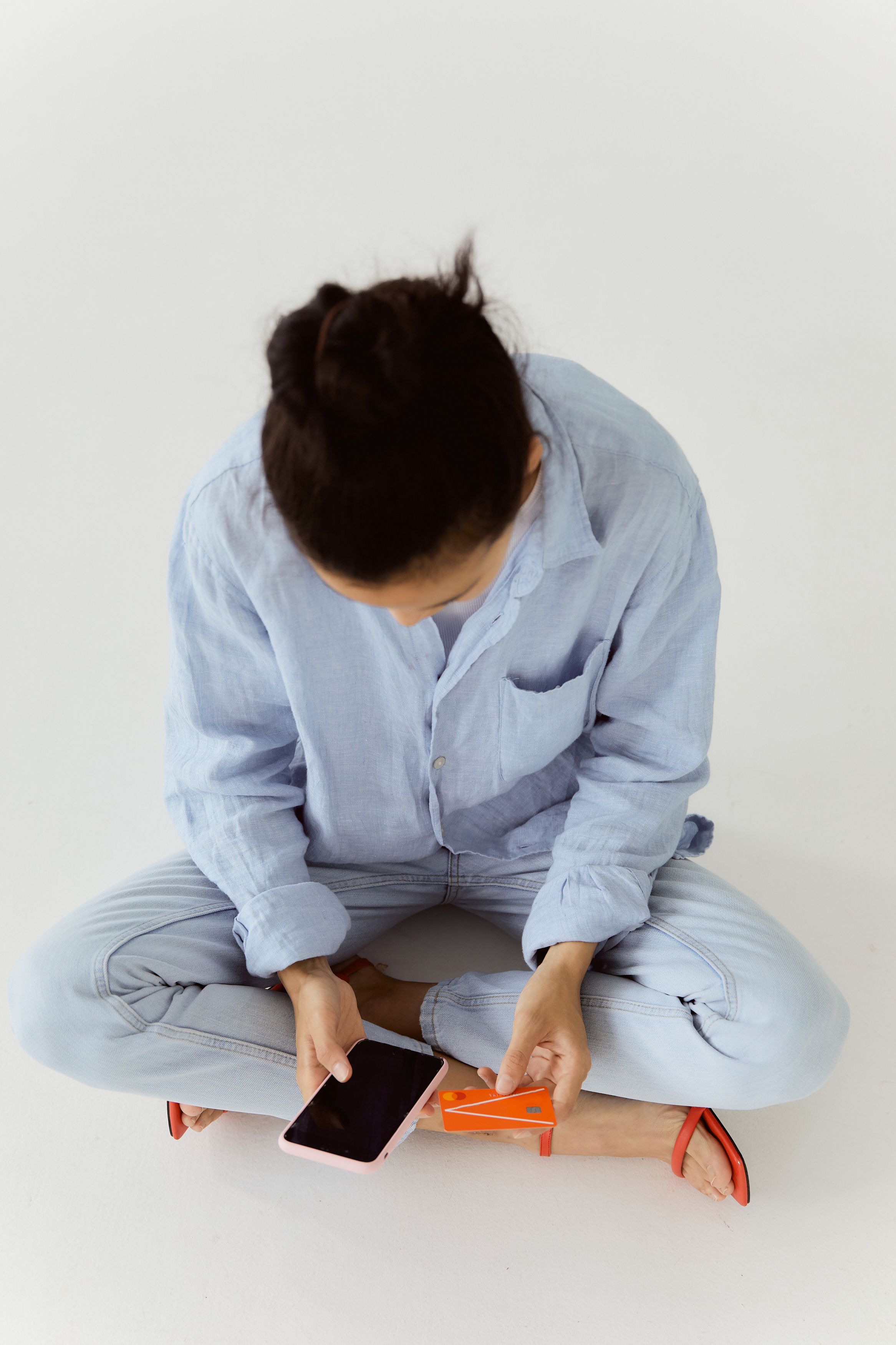 Woman in Blue Long Sleeve Shirt Sitting on White Floor · Free Stock Photo