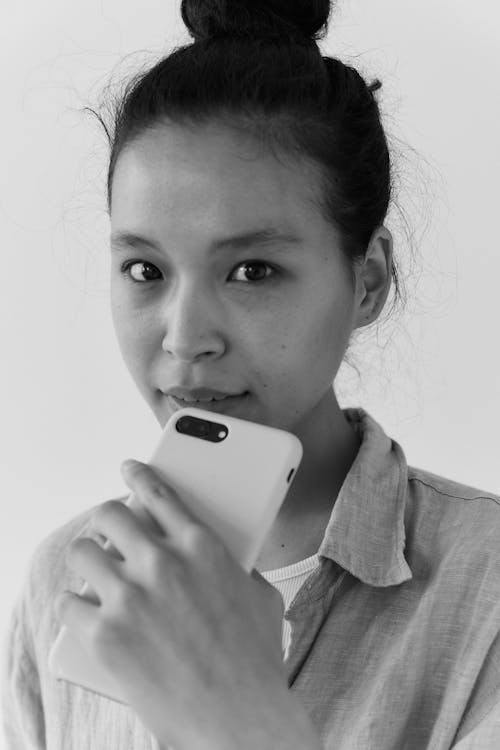 Black and White Photo of a Beautiful Woman Holding a Smartphone