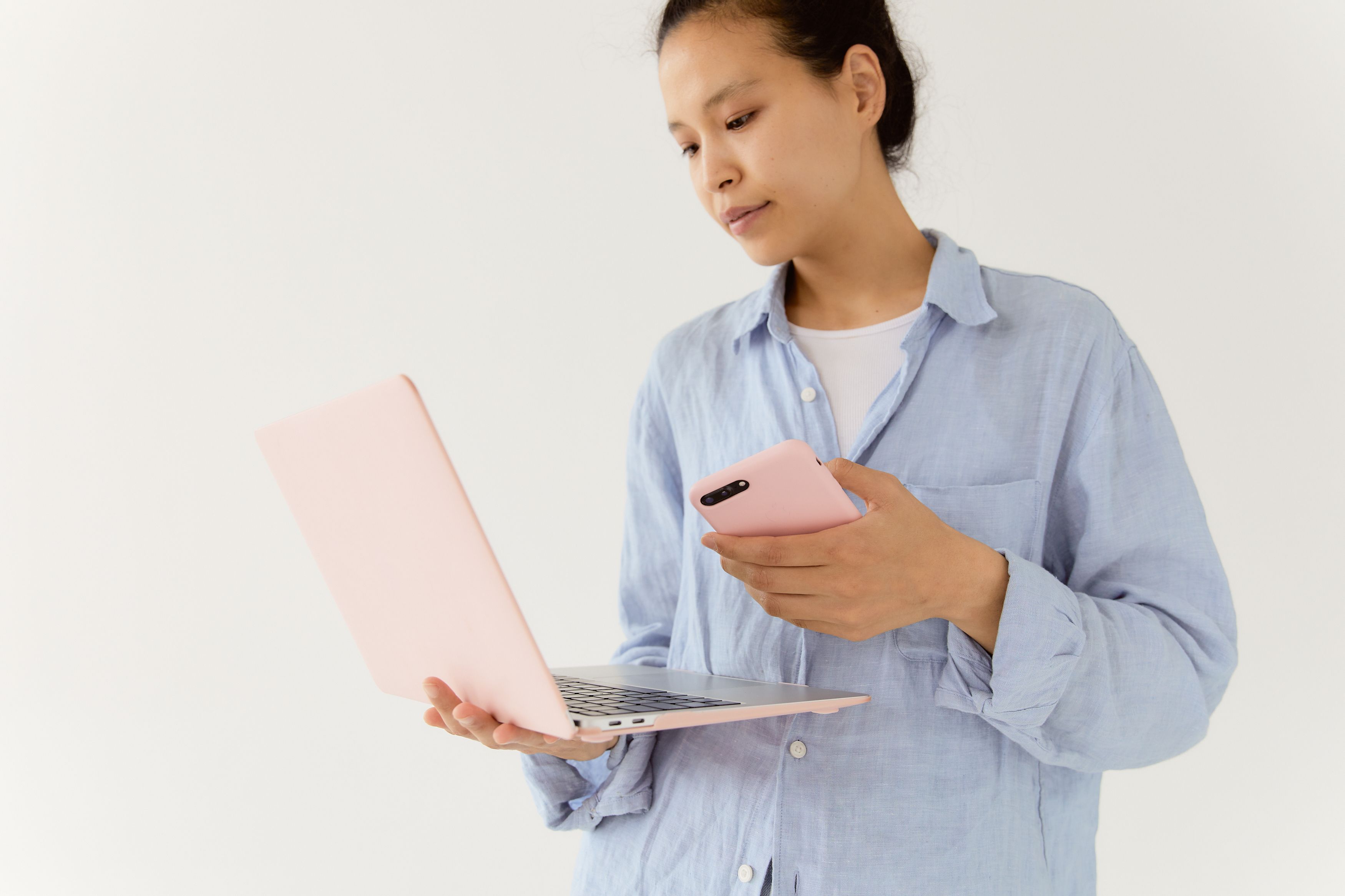 automatic photo backup for phones and laptops - Asian woman using laptop and smartphone