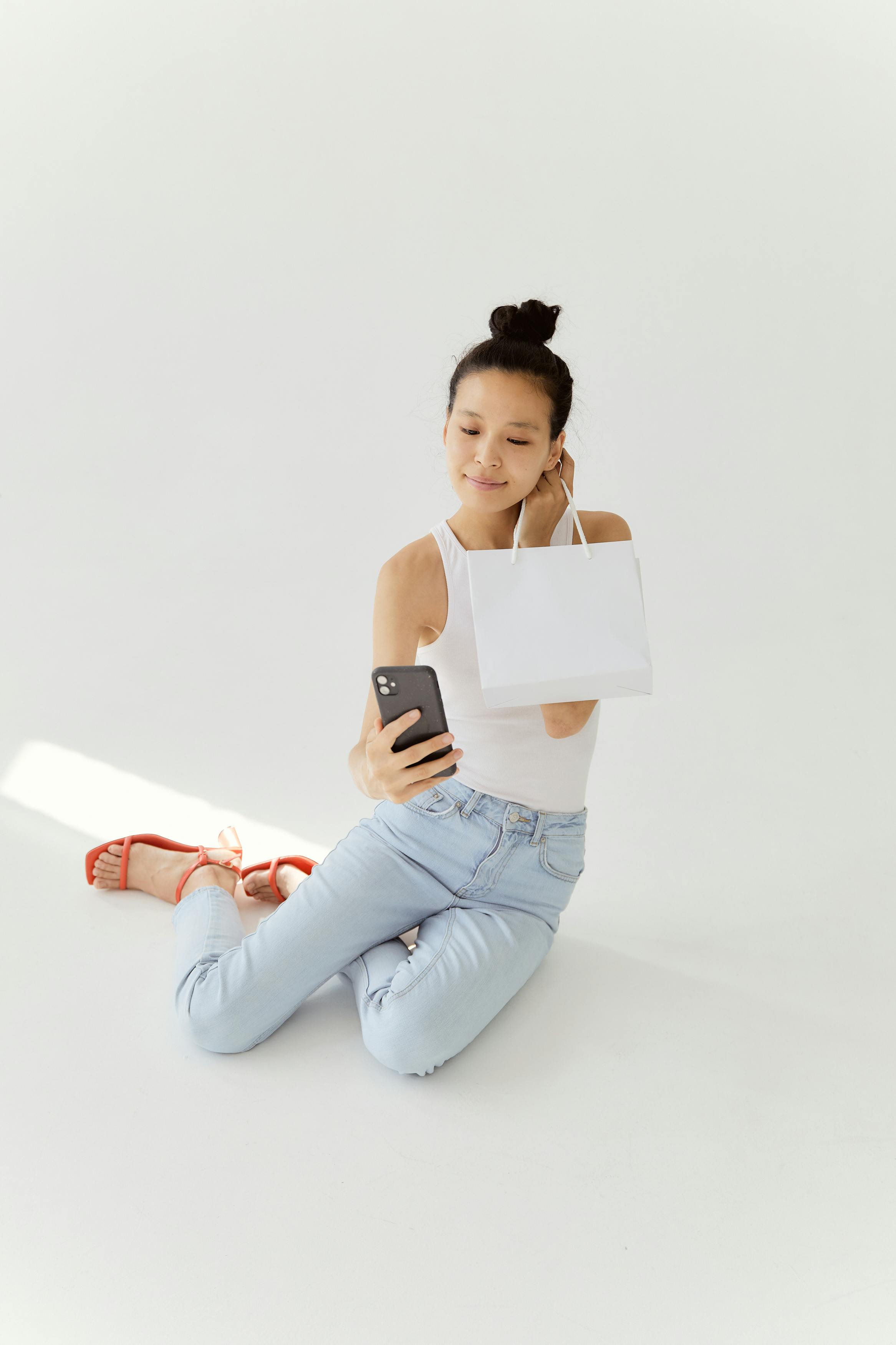 Gratis Mujer Tomándose Un Selfie Mientras Sostiene Una Bolsa De Compras Foto de stock