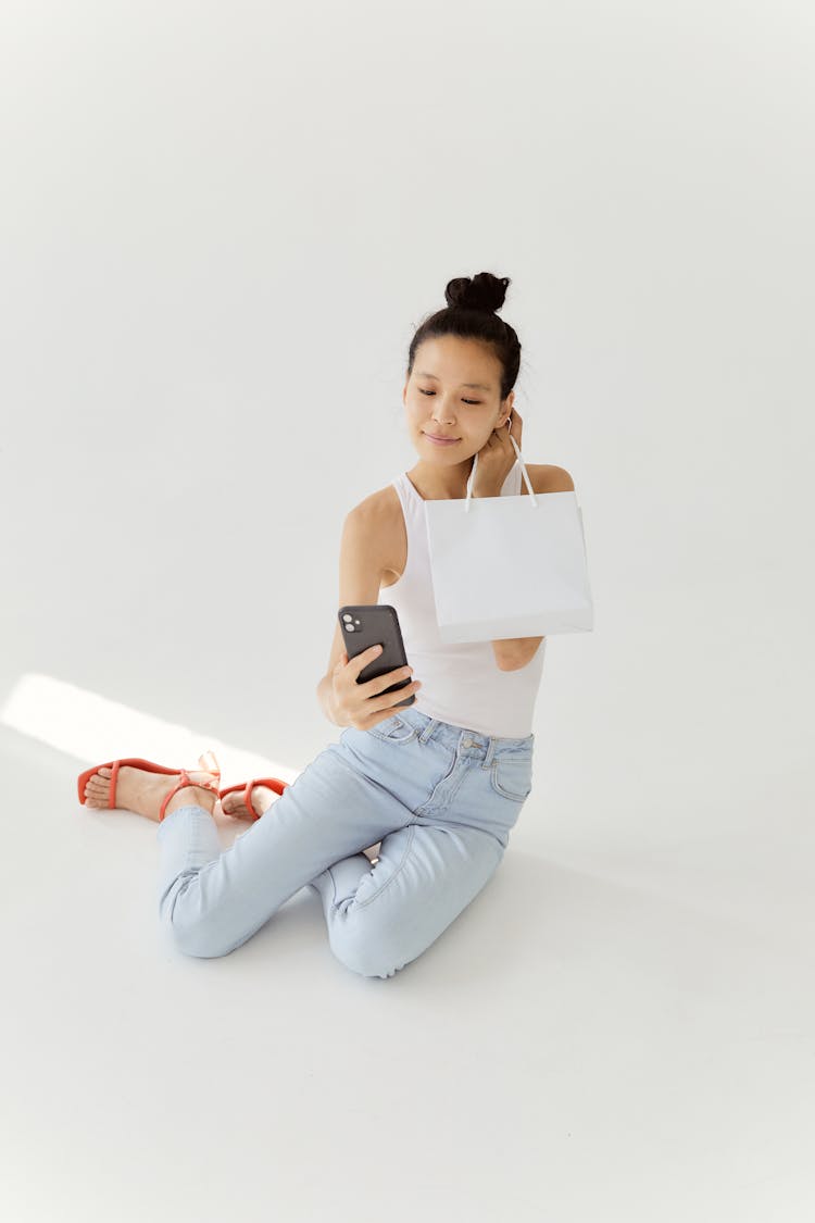 Woman Taking A Selfie While Holding A Shopping Bag