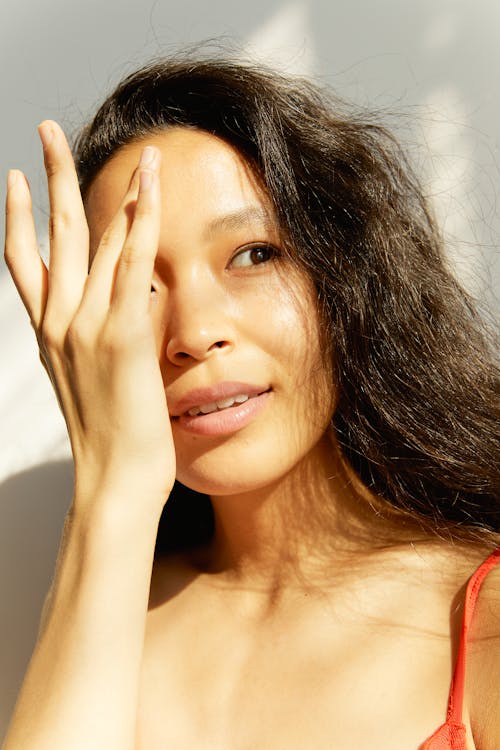 Asyalı kadın, dikey atış, dokunaklı yüz içeren Ücretsiz stok fotoğraf