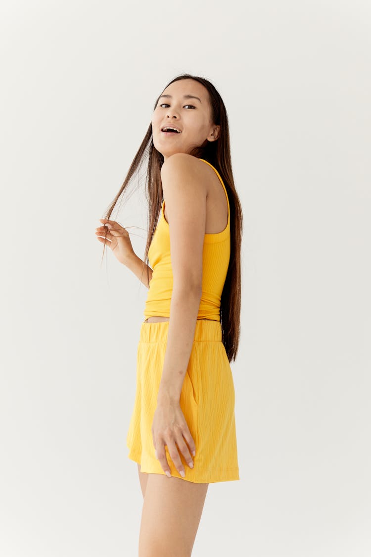 Woman In Yellow Clothes Touching Her Hair