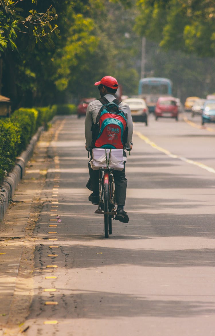 Back View Of A Man Biking On The Road 