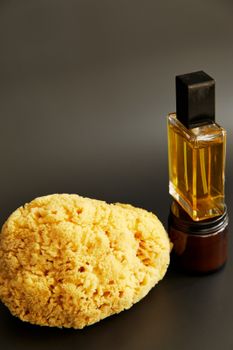 Elegant product shot featuring a perfume bottle alongside a natural sponge on a neutral backdrop.