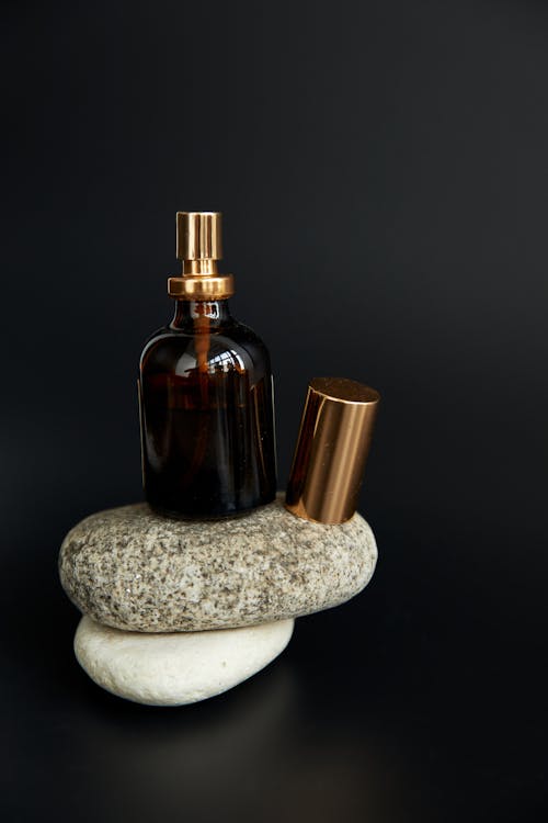 Brown Glass Bottle on White and Gray Stone