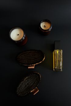 Flat lay of candles, body brushes, and bath oil for a relaxing spa atmosphere.