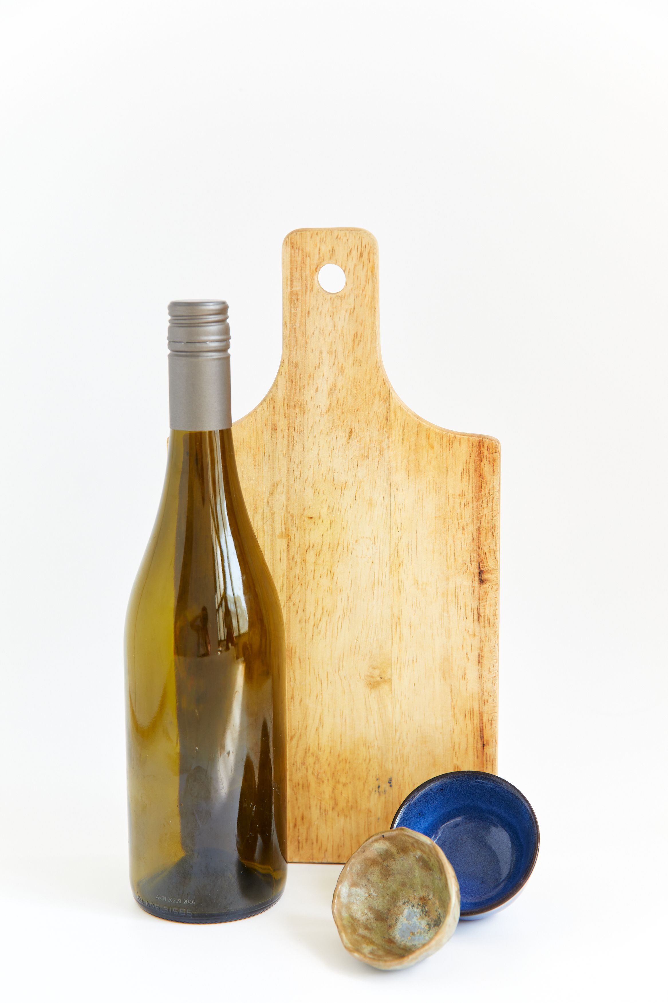 Bottle of white wine beside a wooden cutting board
