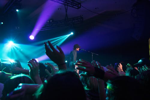 Free Man Singing on Stage With Stage Lights Near Crowd Stock Photo
