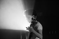 舞台上，一位音乐家正在表演的黑白照片，灯光明亮