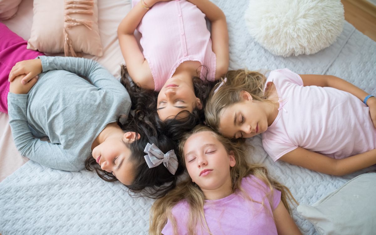 Four young girls peacefully sleeping during a fun sleepover.