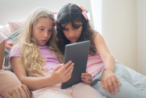 Free Girl in Gray Digital Tablet Sitting on Bed Stock Photo