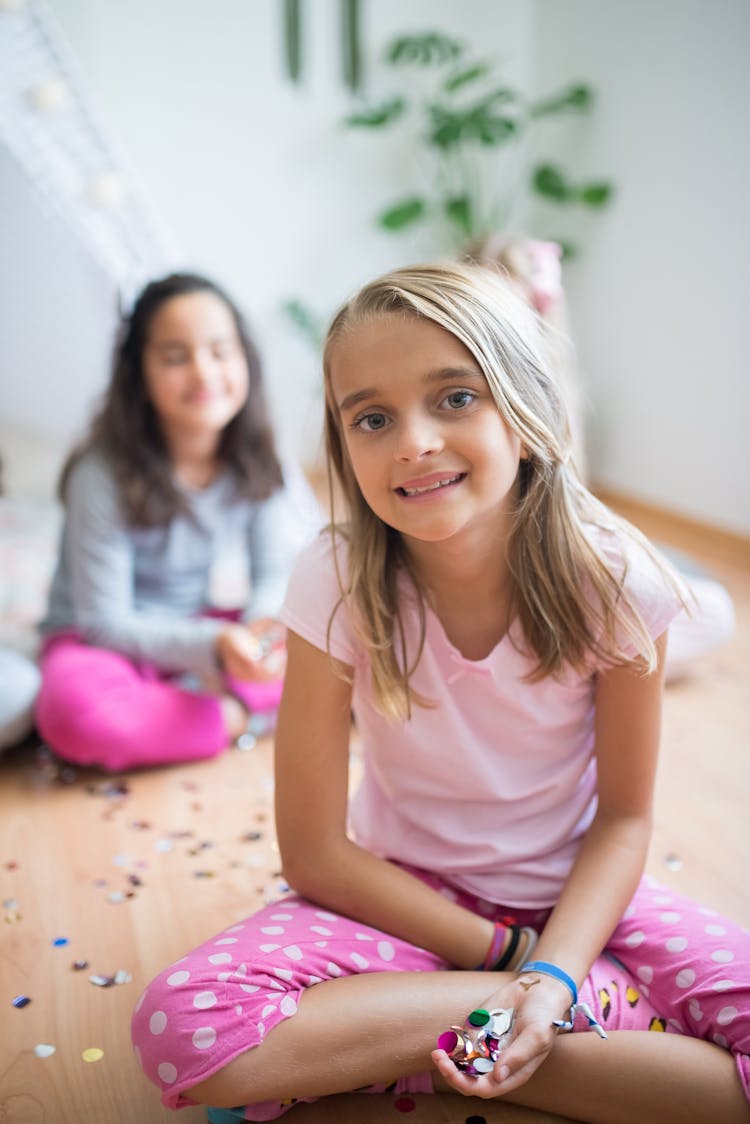 A Smiling Girl With Confetti On Her Hand 