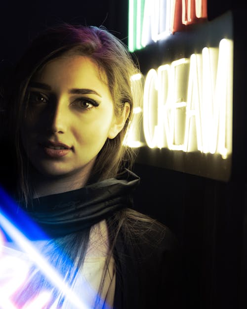 Portrait of a Woman Near a Neon Sign