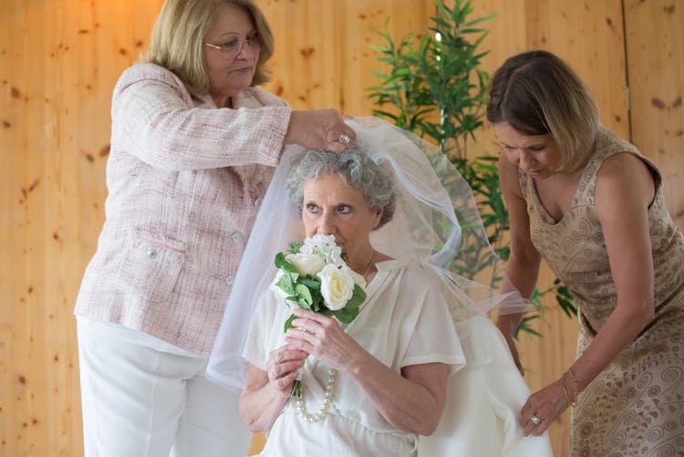 Women Dressing Up A Bride