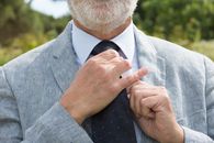 Man in Gray Suit Jacket Holding His Necktie