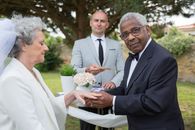 Man in Black Suit Holding Bouquet of Flowers